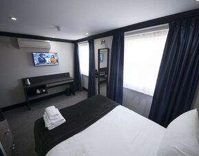 Bright and spacious day use room with TV screen and work desk at The Pack And Carriage London Hotel.