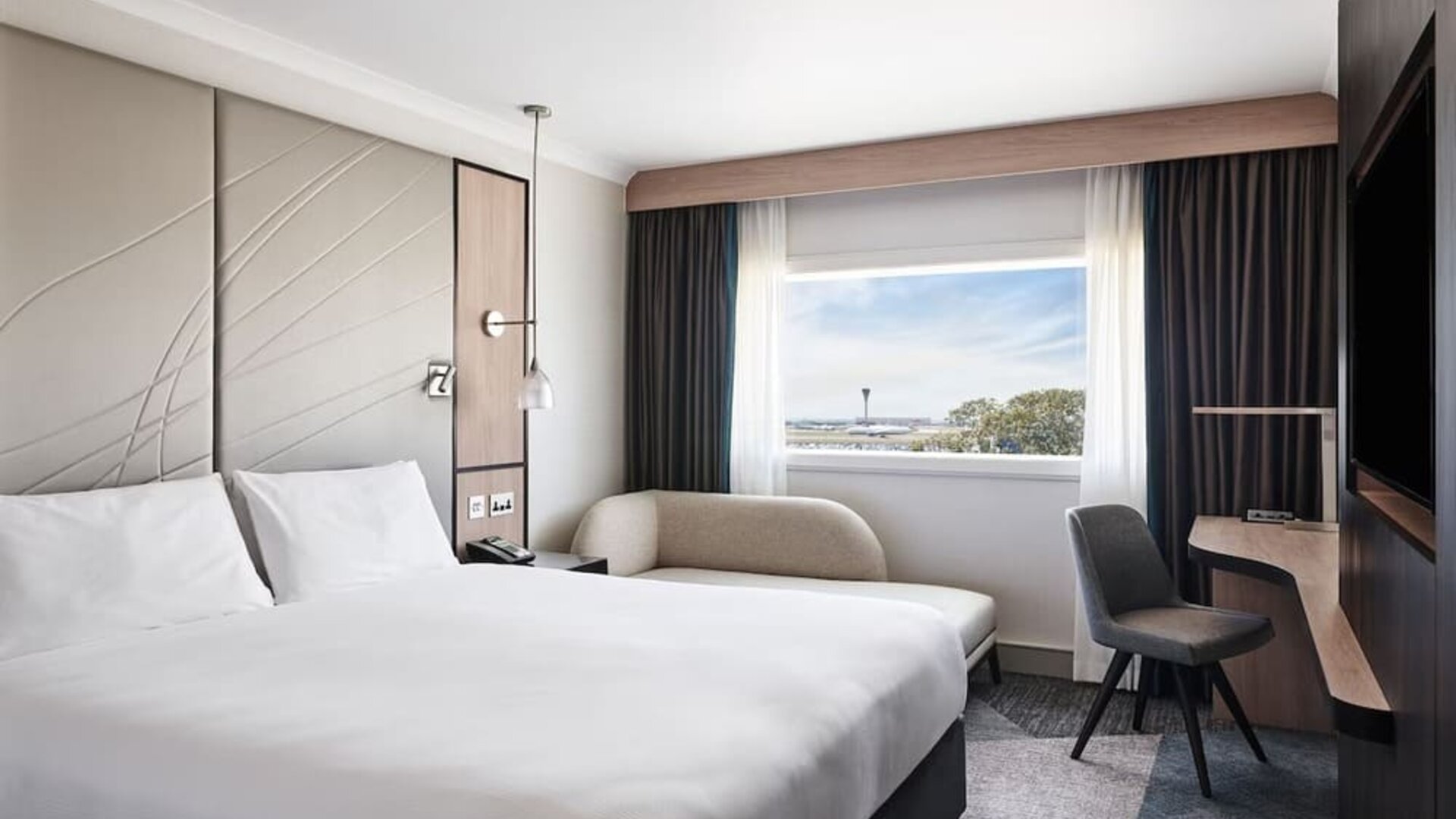 Day use room with sofa, work desk, TV screen and private bathroom