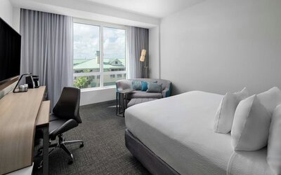 Day use room with sofa and work desk at Courtyard Delray Beach.
