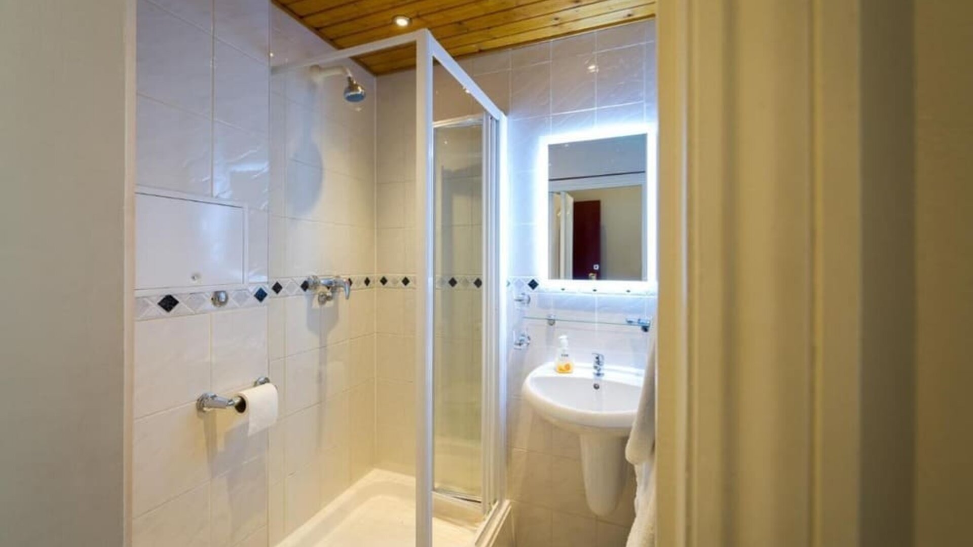 Guest bathroom with shower at Adria Hotel.