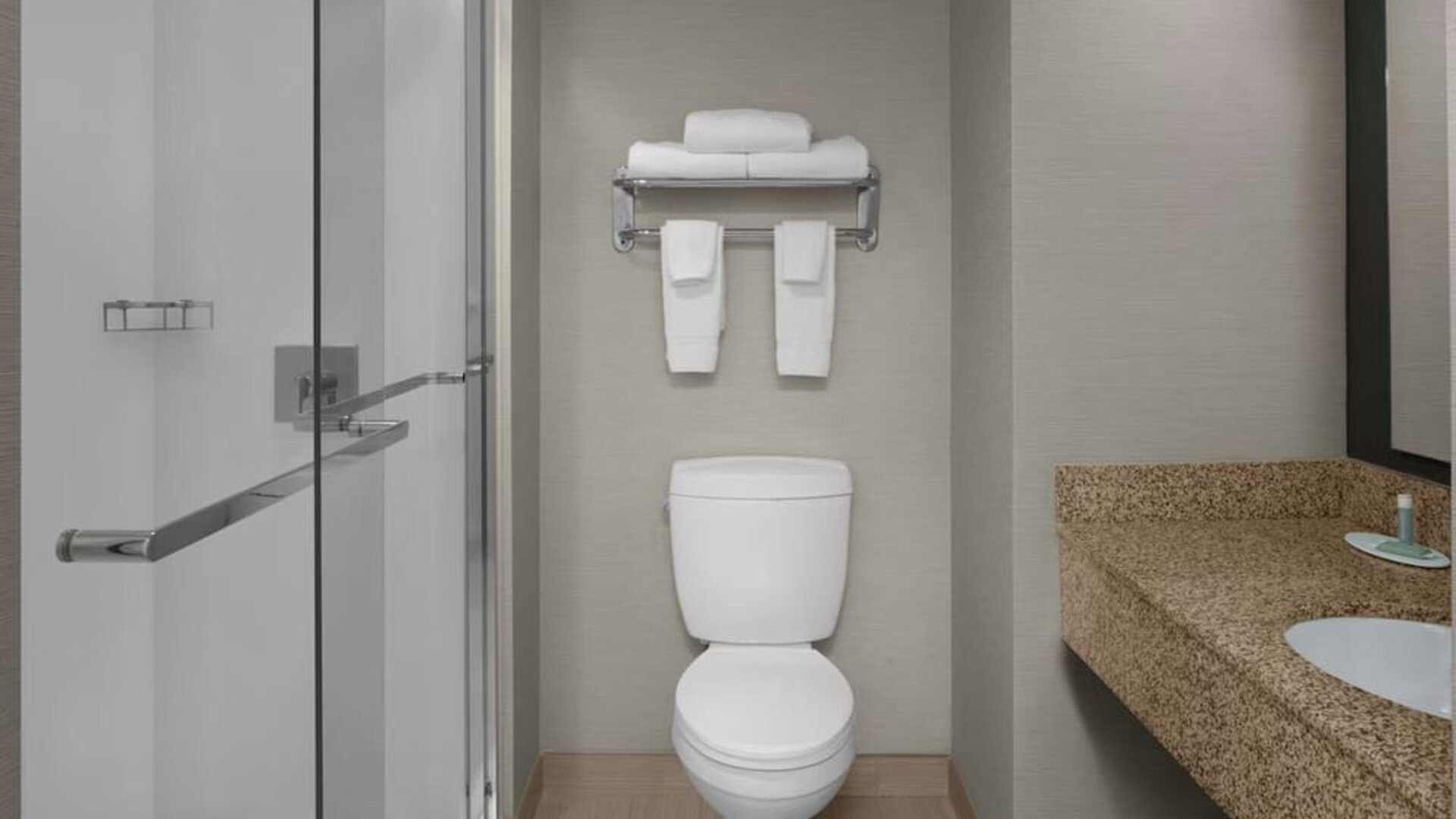 Guest bathroom with shower at Courtyard By Marriott Cypress Anaheim.