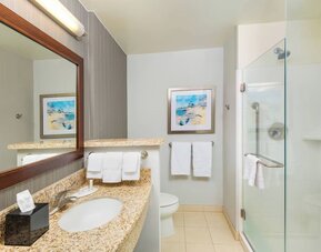 Guest bathroom with shower at Courtyard By Marriott Santa Ana Orange County.