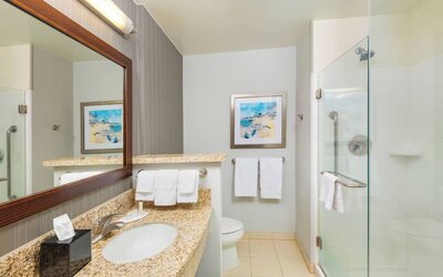 Guest bathroom with shower at Courtyard By Marriott Santa Ana Orange County.