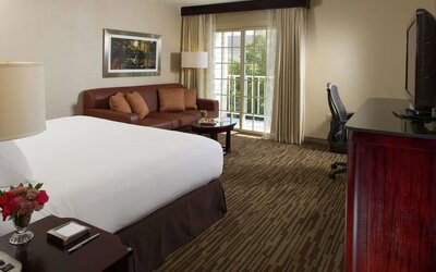 Day use room with sofa, work desk and balcony at DoubleTree Raleigh Durham Airport At Research Triangle Park.