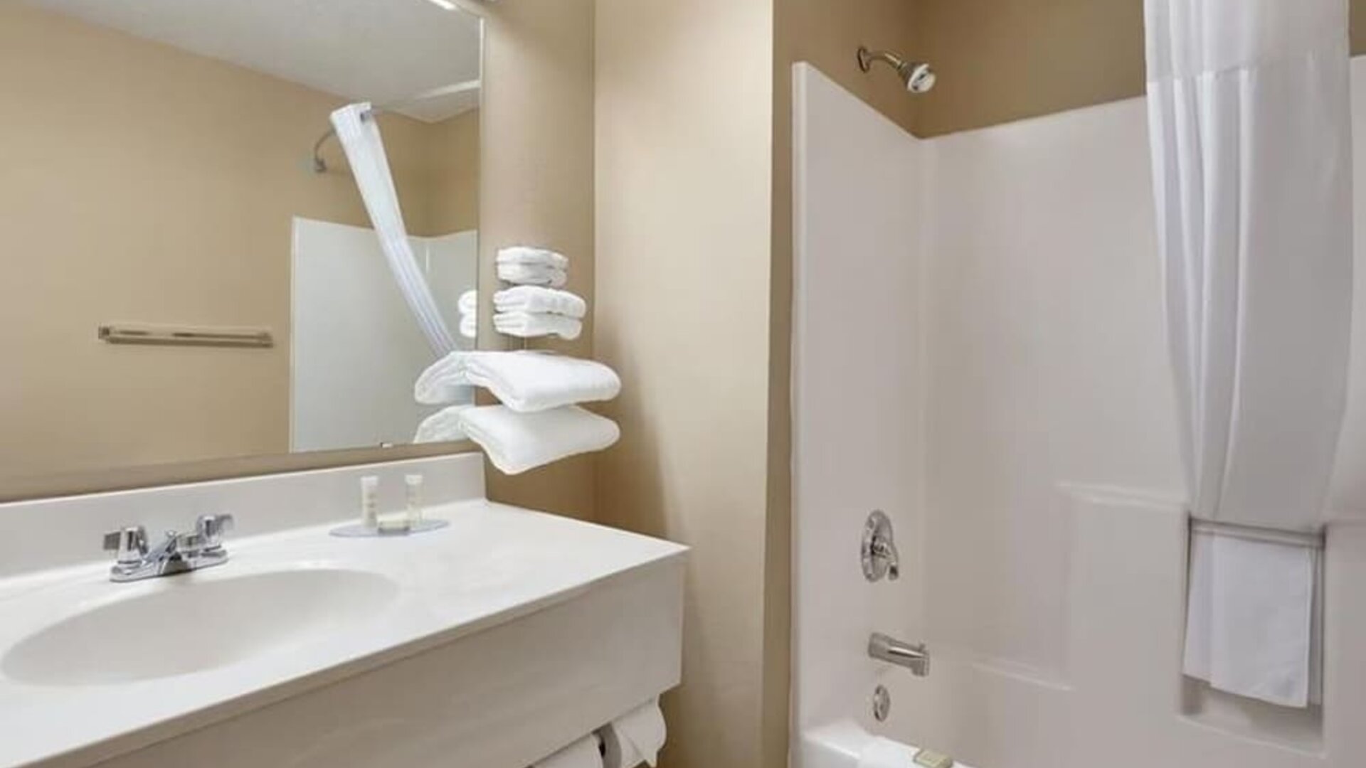 Guest bathroom with shower and tub at Coratel Inn & Suites By Jasper New Richmond.