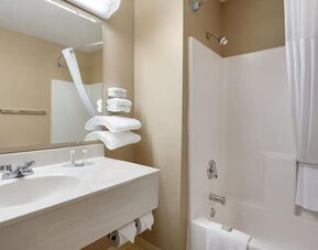 Guest bathroom with shower and tub at Coratel Inn & Suites By Jasper New Richmond.