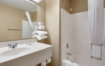 Guest bathroom with shower and tub at Coratel Inn & Suites By Jasper New Richmond.