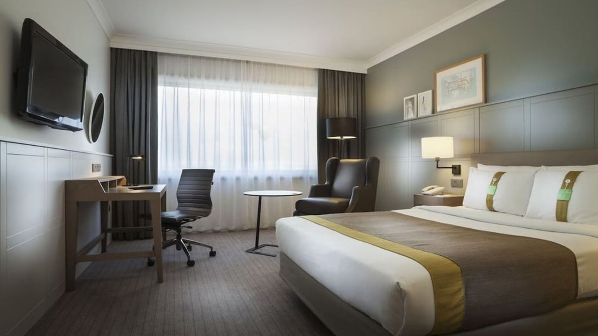 Bright and spacious day use room with work desk, lounge area and TV screen at Holiday Inn London - Heathrow M4J4.