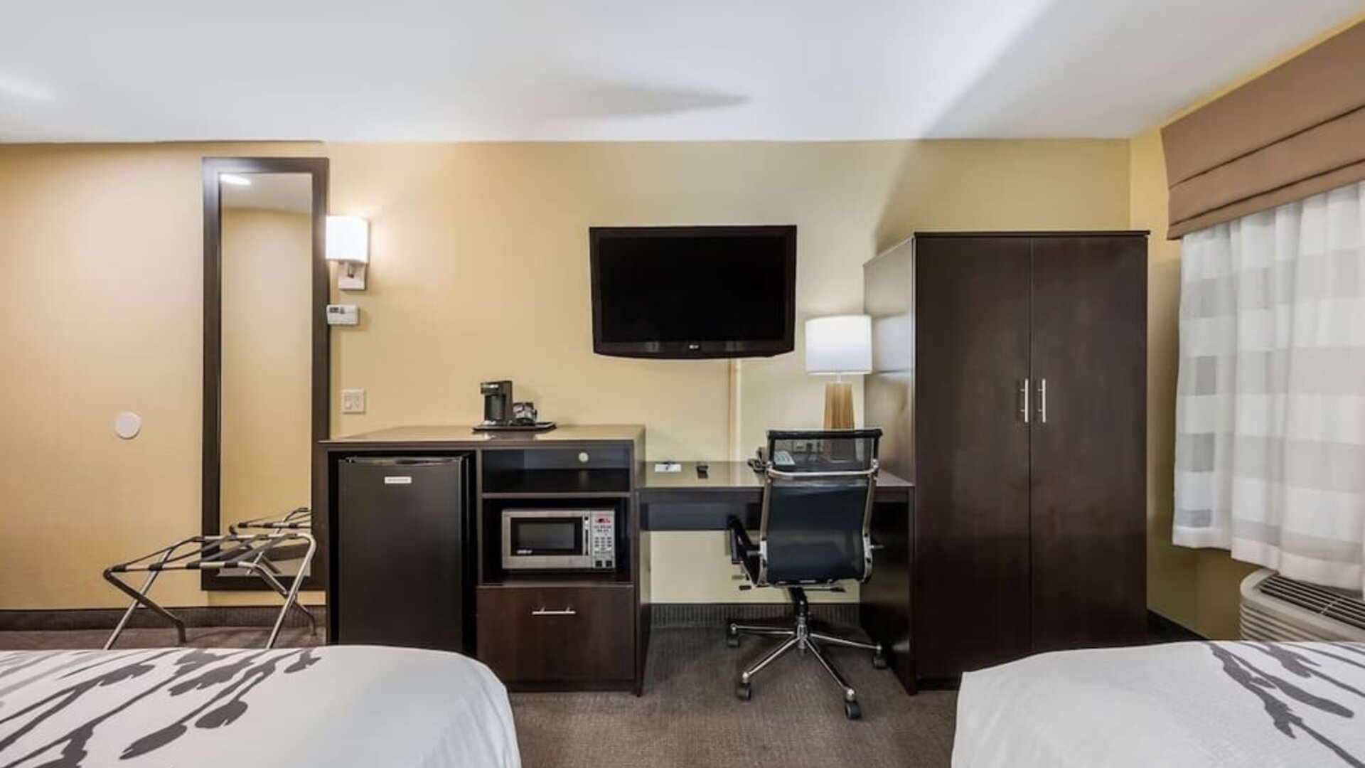 Work station with desk, TV, and mini-fridge at Spark By Hilton Oxford.
