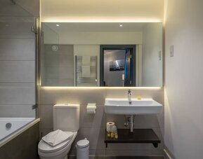 Private guest bathroom with combined shower at Pelican London Residence & Hotel.and tub 