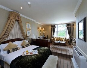 Junior suite with work desk and lounge area at The Colonnade Hotel.