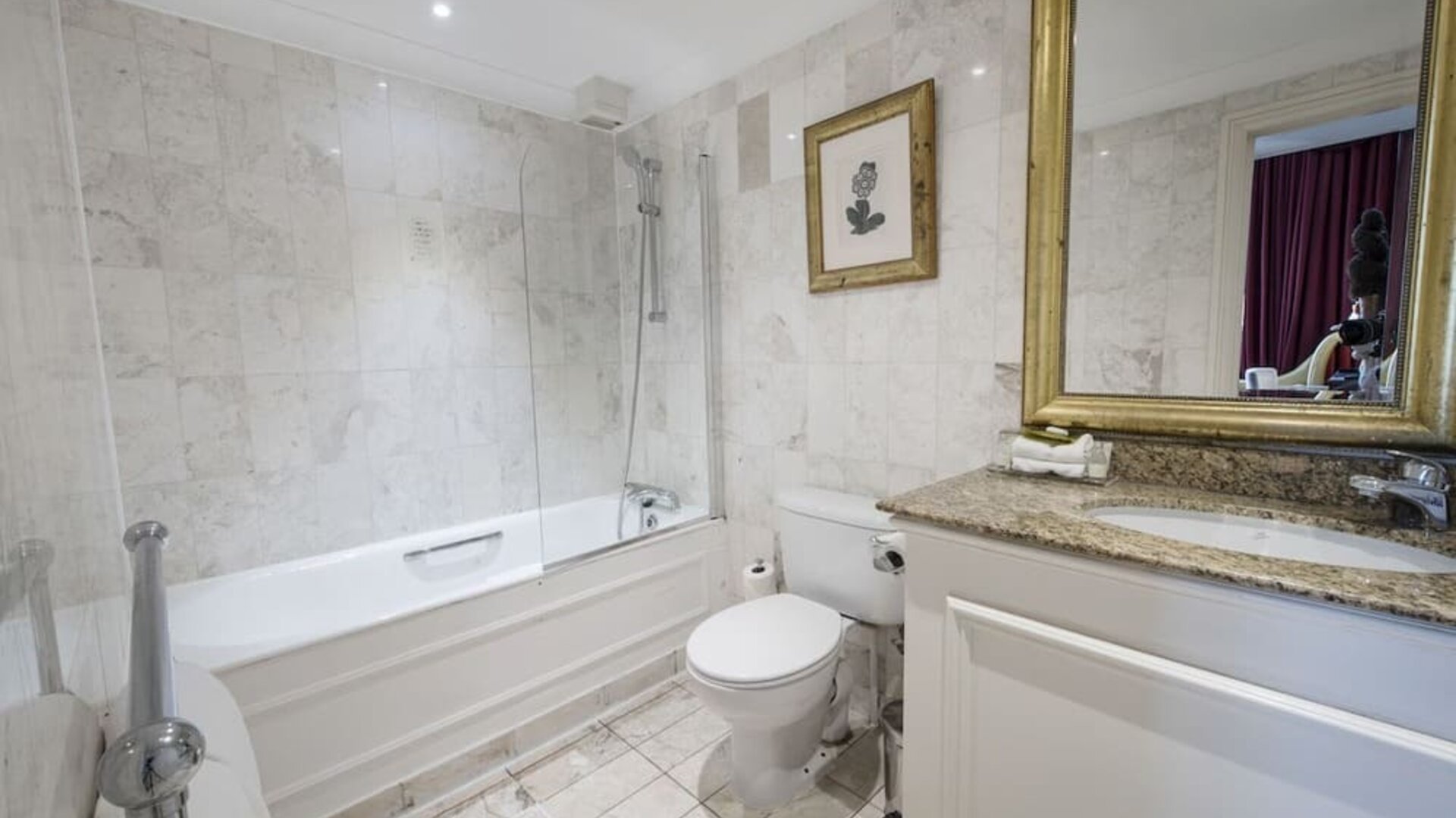 Private guest bathroom with combined tub and shower at The Colonnade Hotel.