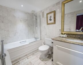 Private guest bathroom with combined tub and shower at The Colonnade Hotel.