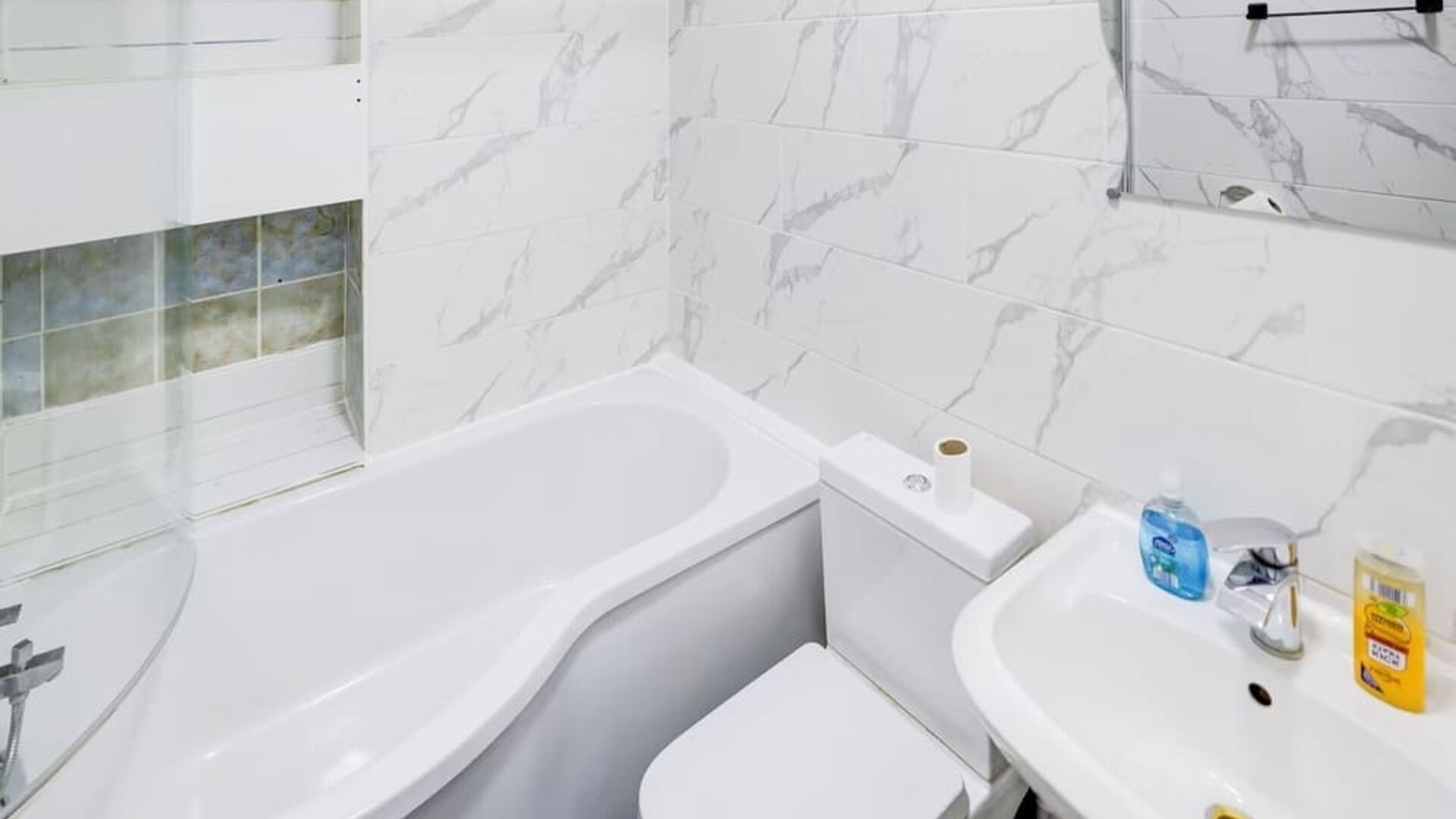 Private guest bathroom with tub and free toiletries at London Shelton Hotel.