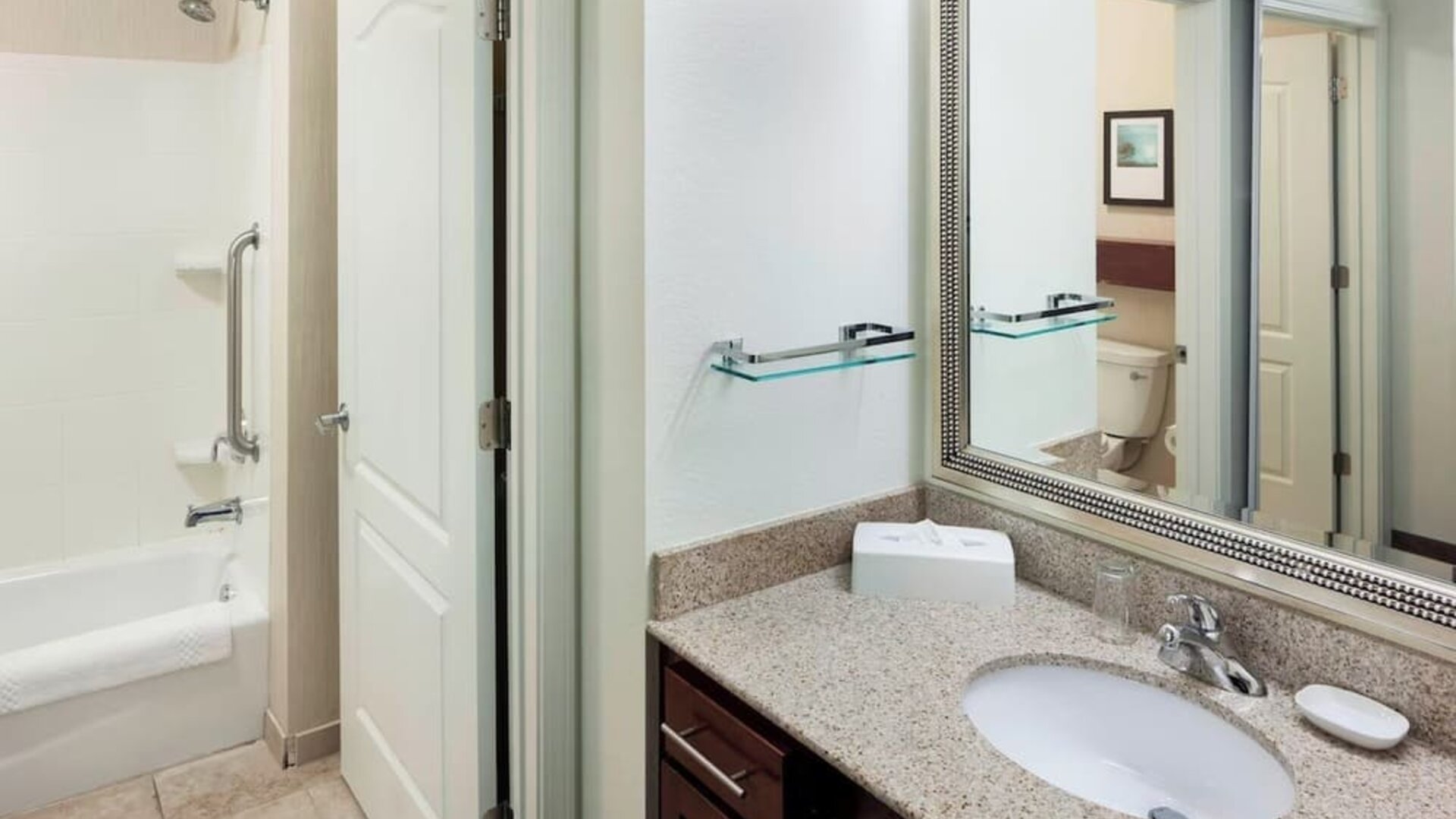 Guest bathroom with shower and tub at Residence Inn By Marriott Hattiesburg.