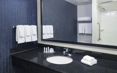 Guest bathroom with shower and tub at Fairfield Inn & Suites Kansas City Overland Park.