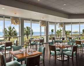 Dining area with natural light perfect for coworking at Embassy Suites By Hilton Myrtle Beach Oceanfront Resort.