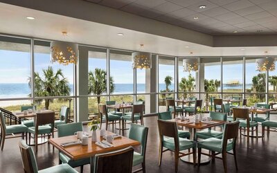 Dining area with natural light perfect for coworking at Embassy Suites By Hilton Myrtle Beach Oceanfront Resort.