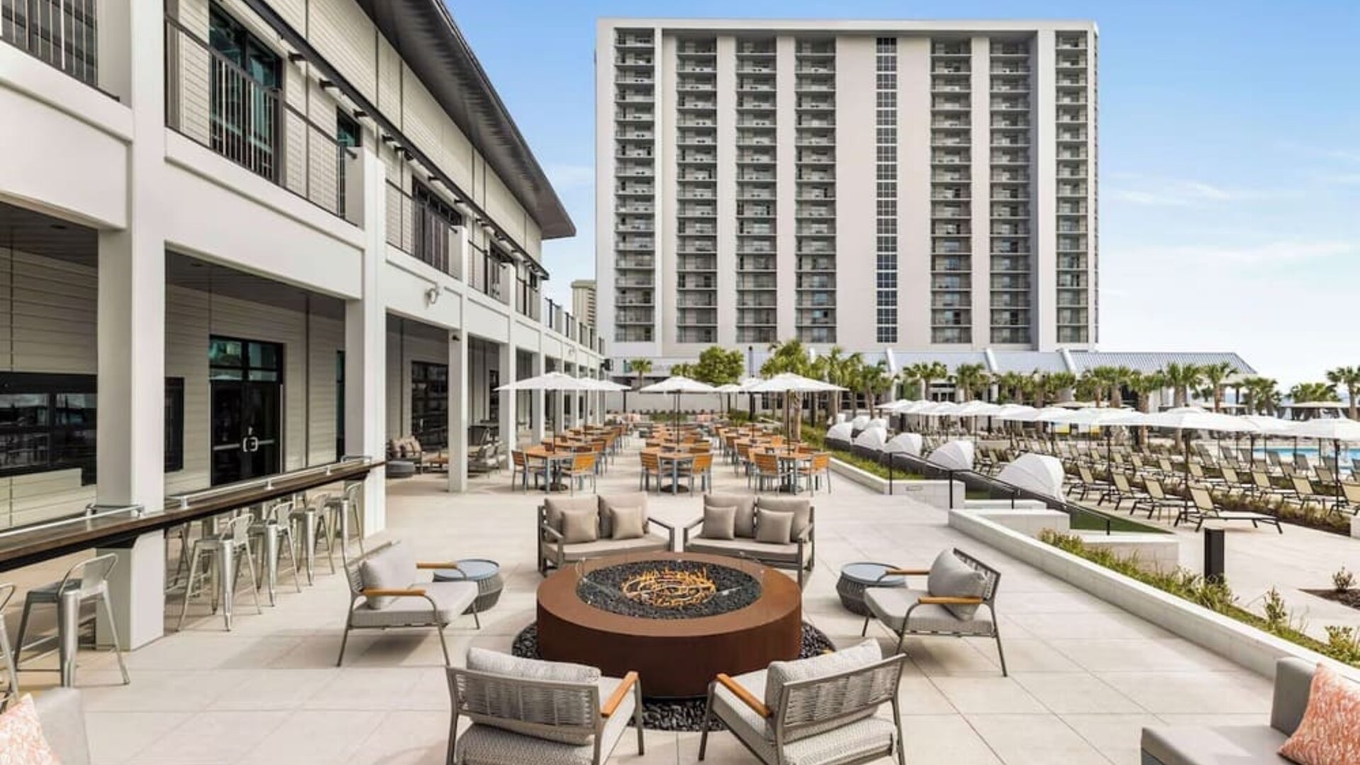 Firepit and plenty of outdoor seats near pool area at Embassy Suites By Hilton Myrtle Beach Oceanfront Resort.