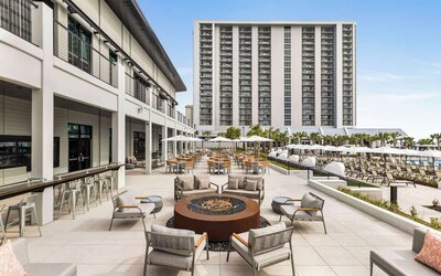 Firepit and plenty of outdoor seats near pool area at Embassy Suites By Hilton Myrtle Beach Oceanfront Resort.