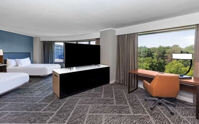 Two queen beds in a spacious day use room with work desk at DoubleTree By Hilton Tulsa - Warren Place.