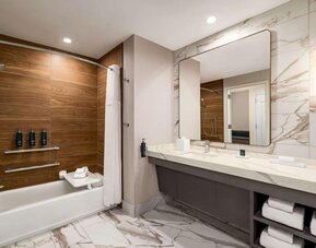 Private guest bathroom with tub at Hilton BNA Nashville Airport Terminal.

