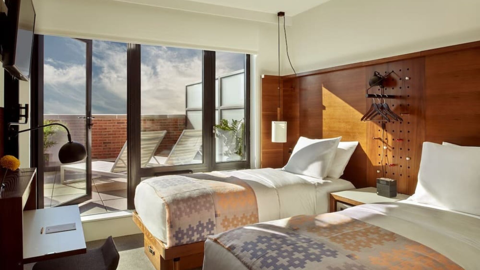 Bright and spacious day use twin room with workdesk and balcony with lounge seating at Arlo SoHo.