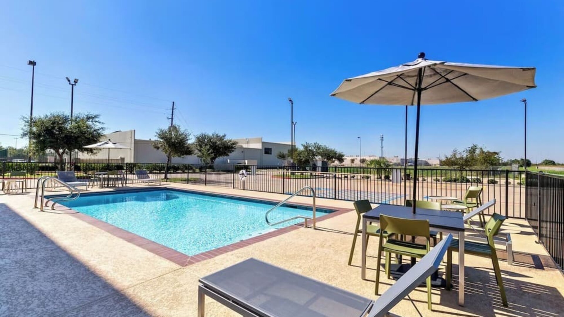 Relaxing outdoor pool with lounge chairs at Spark By Hilton Pearland.