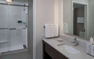 Private guest bathroom with shower and free toiletries at Sonesta ES Suites Fairfax Fair Lakes.