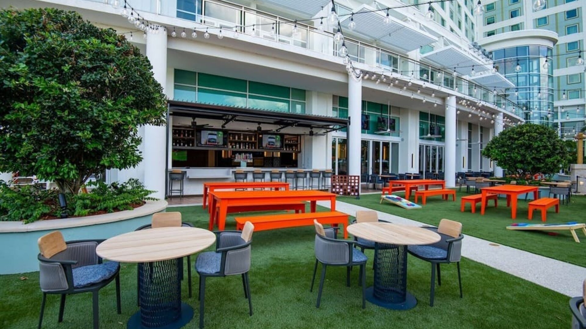 Alfresco dining and lounge area beside a bar at Hilton Orlando.