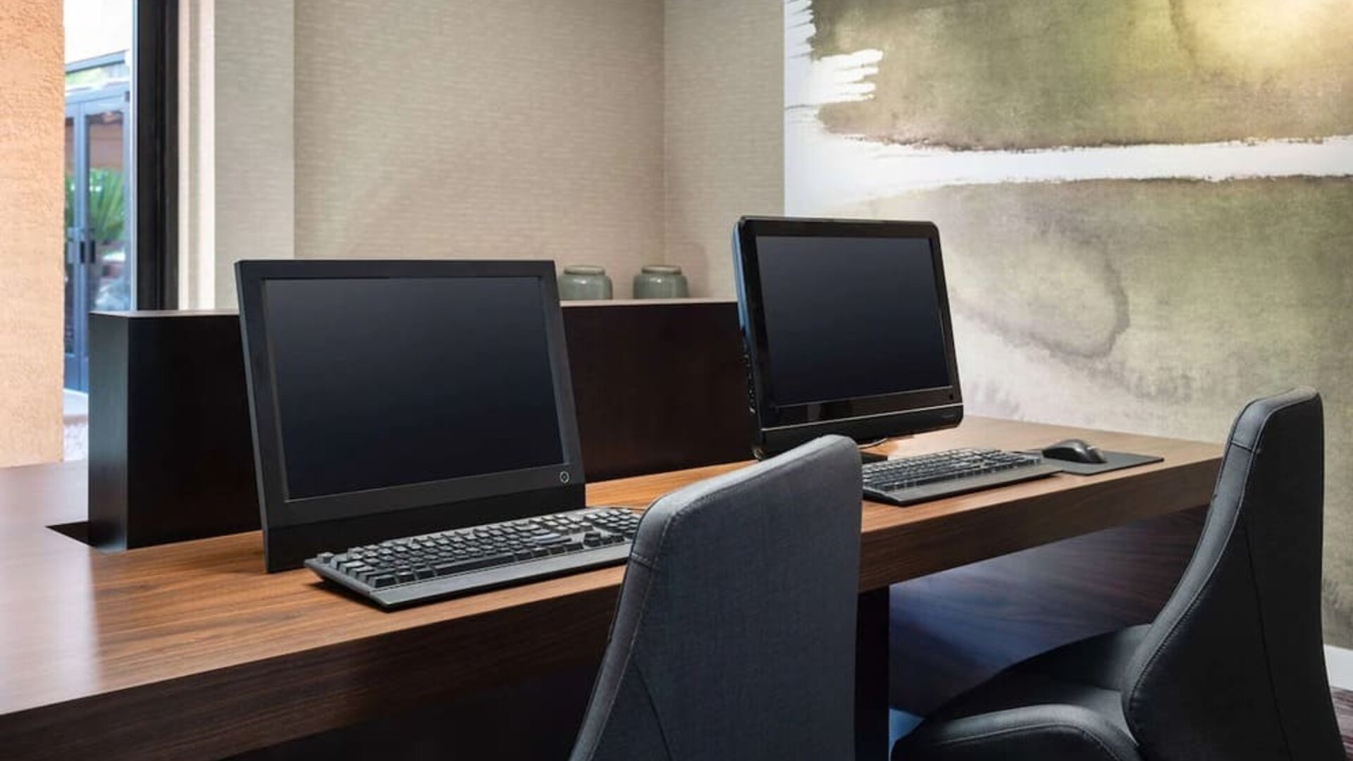 Business center with computers and ergonomic chairs at Sonesta Select Phoenix Camelback.