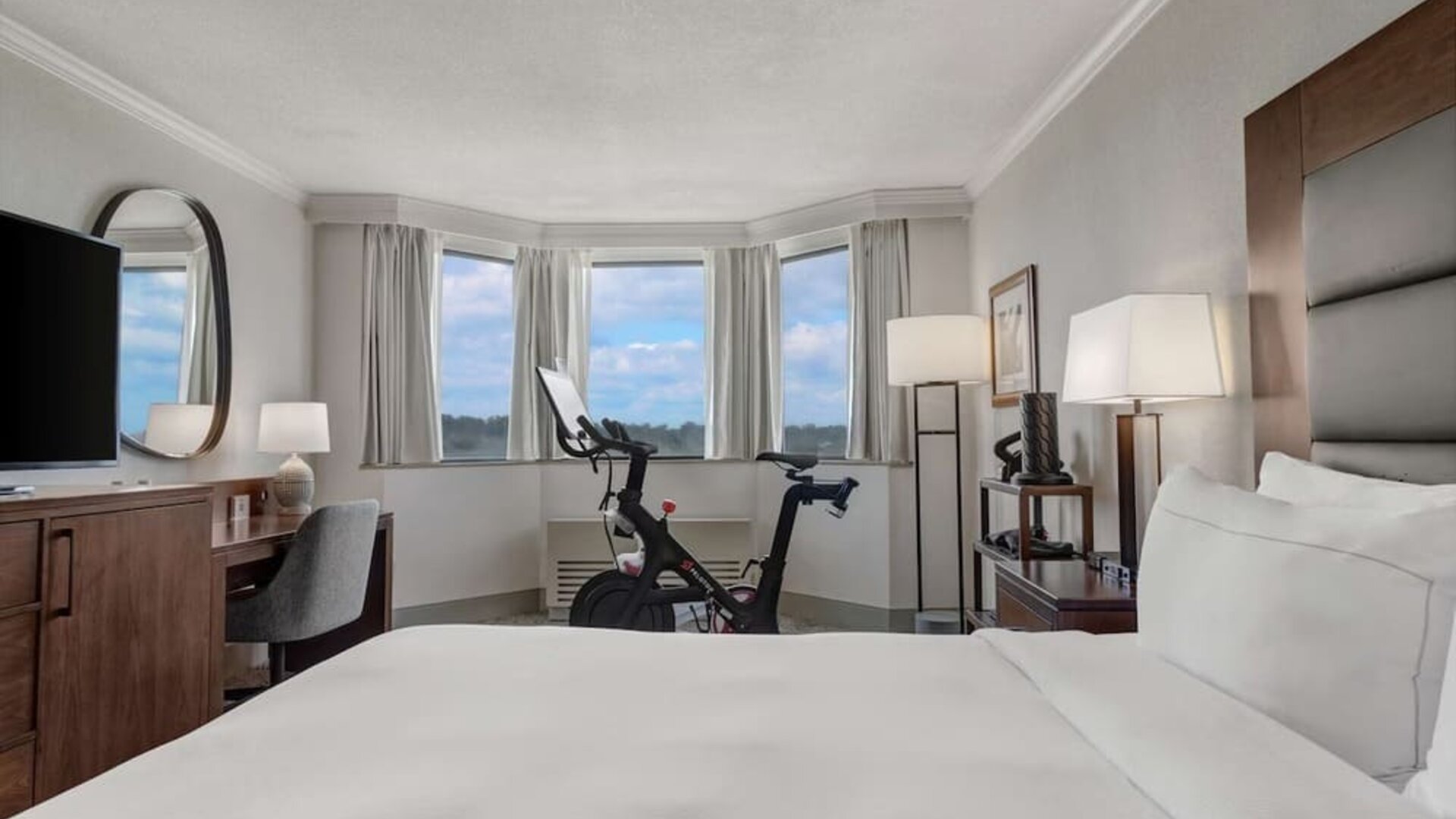 Day use room with work desk and Peloton bike at Hilton Crystal City At Washington Reagan National Airport.