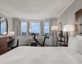 Day use room with work desk and Peloton bike at Hilton Crystal City At Washington Reagan National Airport.