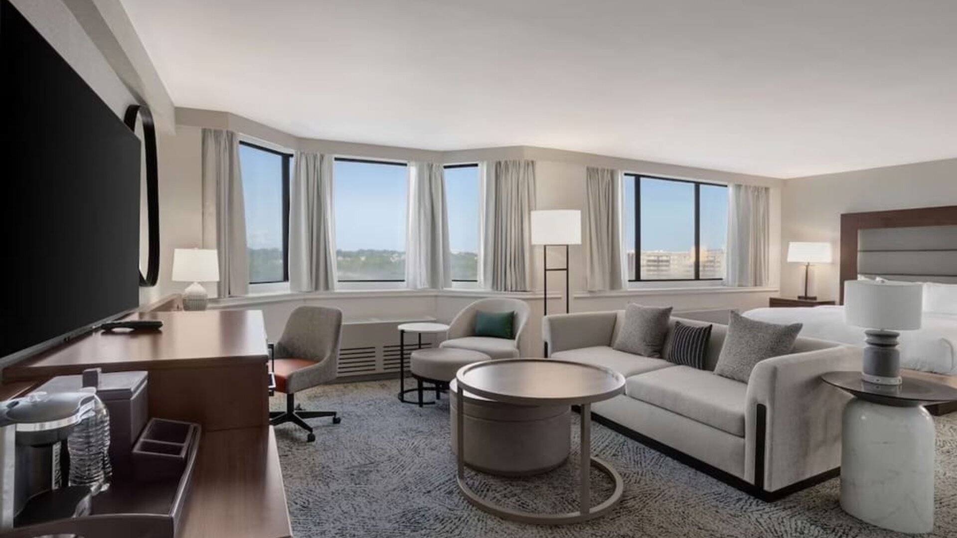 Beautiful king suite with work desk, TV, and sofa at Hilton Crystal City At Washington Reagan National Airport.