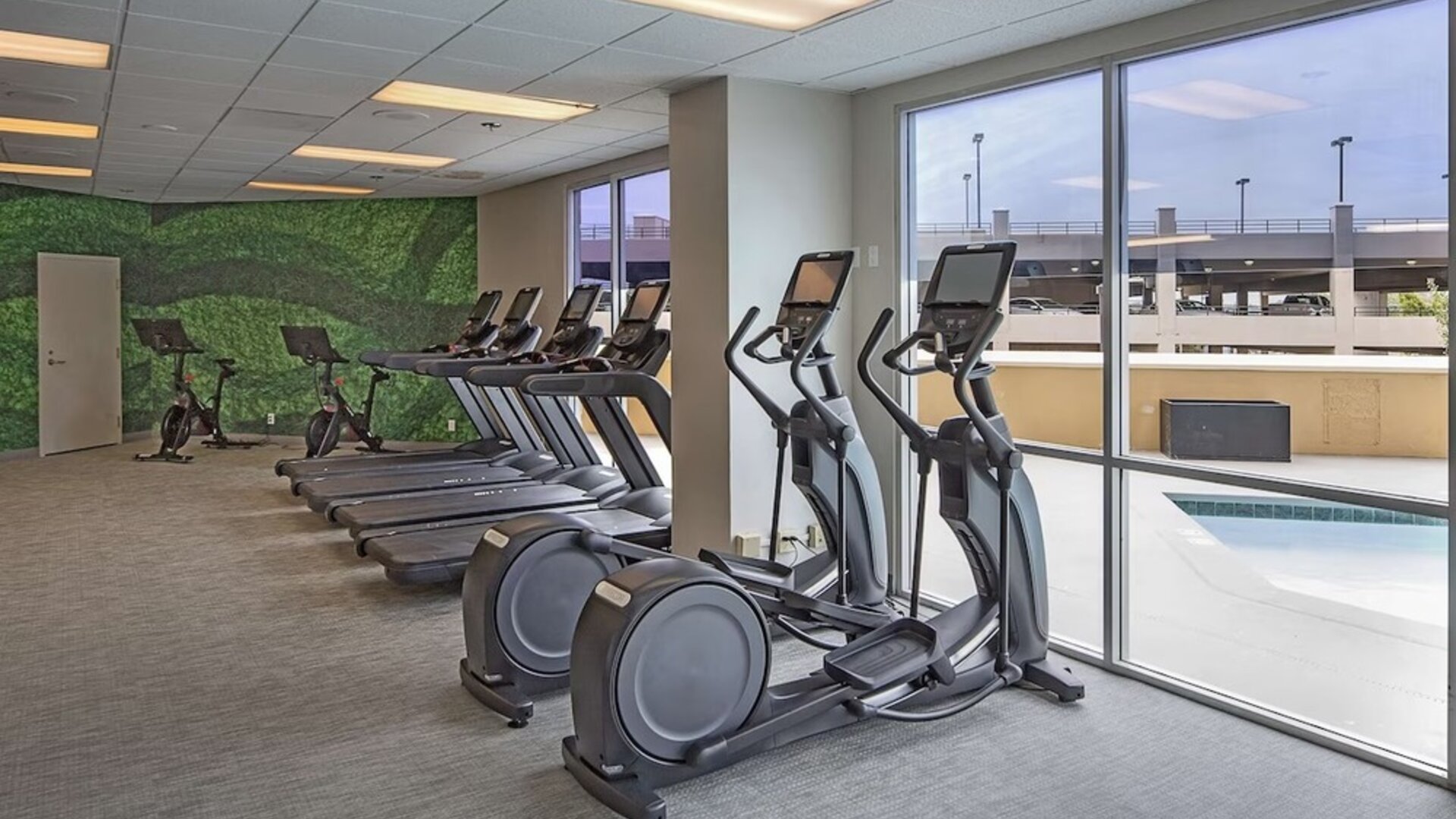 Fitness center with a view of the pool at DoubleTree By Hilton Modesto.
