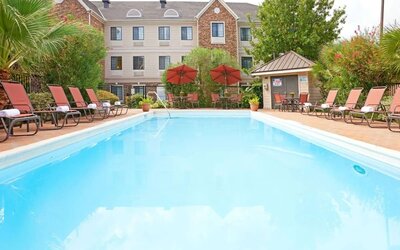 Outdoor pool with lounge chairs at Sonesta ES Suites Dallas Las Colinas.