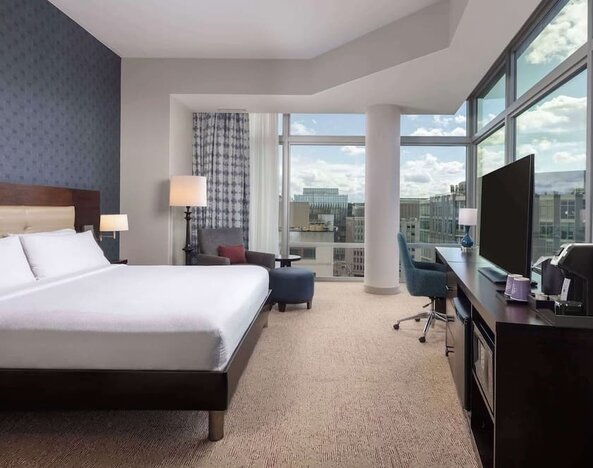 Bright king room with work station and a view of the city at Hilton Garden Inn Washington DC/Georgetown Area.
