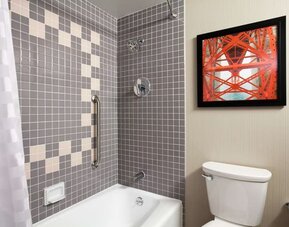 Guest bathroom with shower and tub at Embassy Suites By Hilton San Francisco Airport Waterfront.