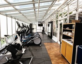Fitness center with natural light at Embassy Suites By Hilton San Francisco Airport Waterfront.