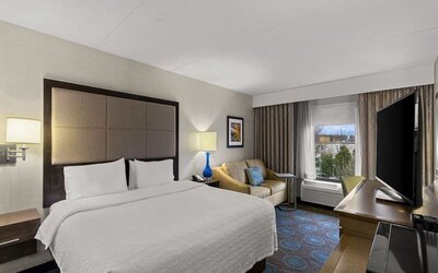 Comfortable king room with sofa and work desk at Hampton Inn Bloomington.