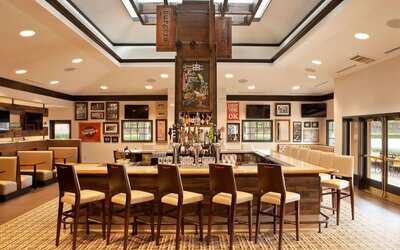 Sonesta Atlanta Airport South’s bar has numerous televisions on the wall, tall bar stools and booth seating, and a broad range of beverages.