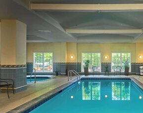 Indoor pool with lounge chairs at Sonesta Atlanta Airport South.