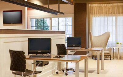 Business center with computers, printer and comfortable seating at Sonesta Atlanta Airport South.