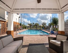 Outdoor pool with lounge area at Sonesta Simply Suites Miami Airport Doral. 