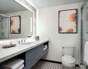 Private guest bathroom with shower and free toiletries at Sonesta Los Angeles Airport LAX.