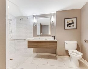 Private guest bathroom with shower and free toiletries at Sonesta Anaheim Resort Area.