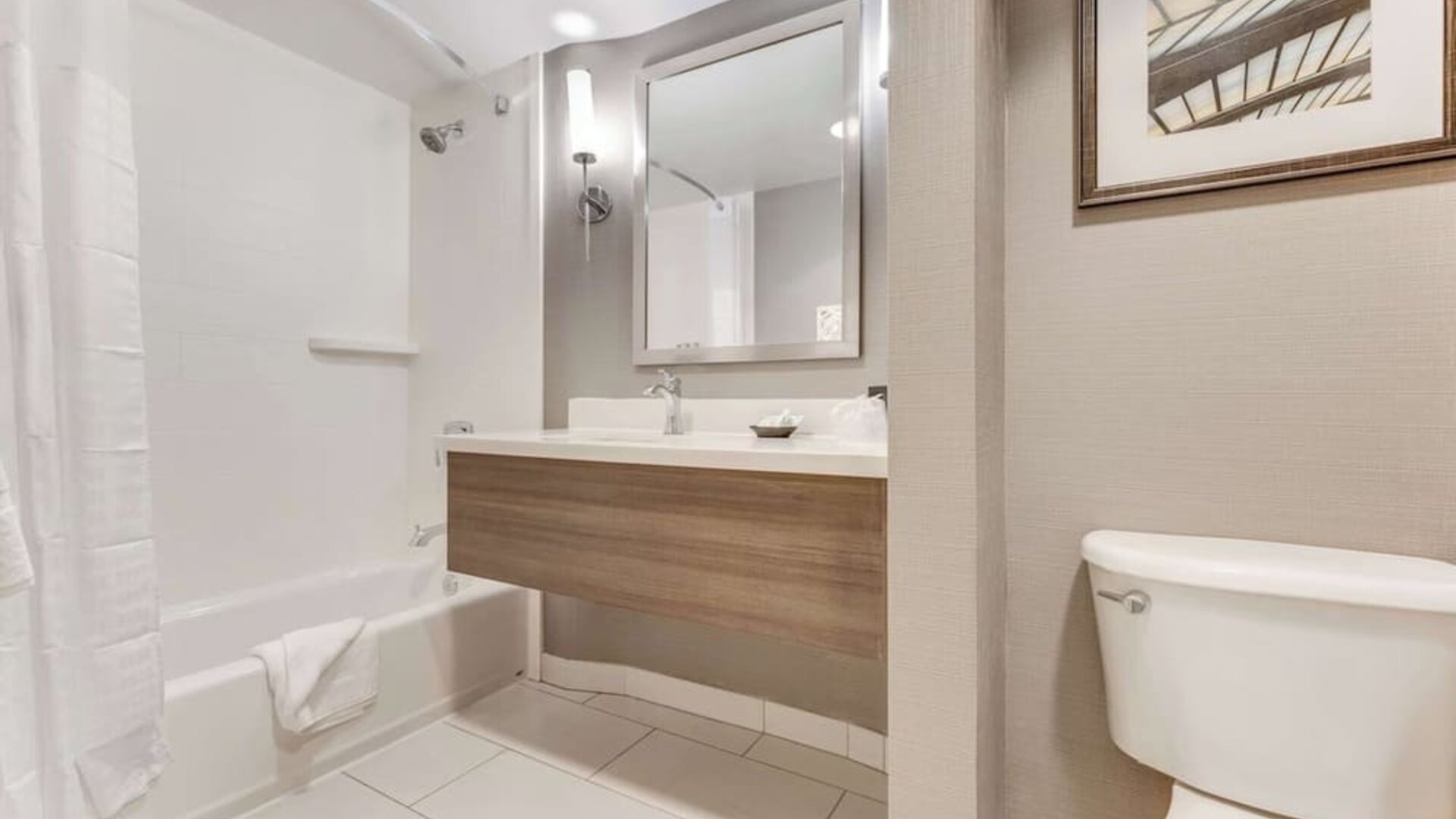 Private guest bathroom with combined shower and tub at Sonesta Anaheim Resort Area.
