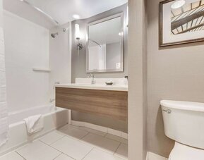 Private guest bathroom with combined shower and tub at Sonesta Anaheim Resort Area.
