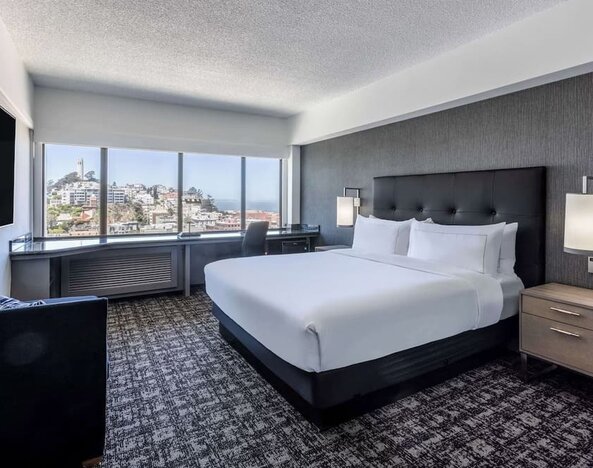 Day use room with sofa and work desk overlooking the city at Hilton San Francisco Financial District.
