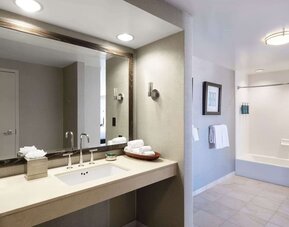 Guest bathroom with shower and tub at Hilton San Francisco Financial District.